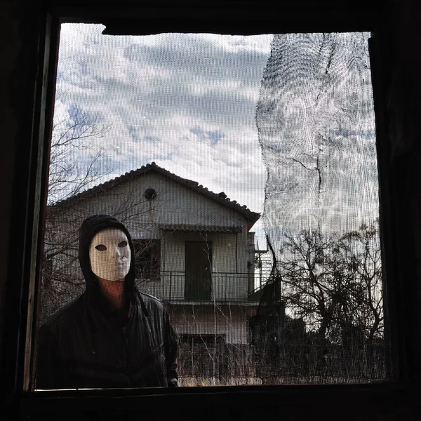 Hooded figur gängade fönster — Stockfoto