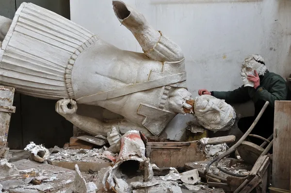 Statue cassée et homme avec fragment de masque en plâtre — Photo