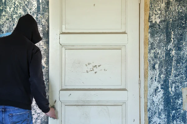 Homem que abre a porta do quarto deteriorado — Fotografia de Stock