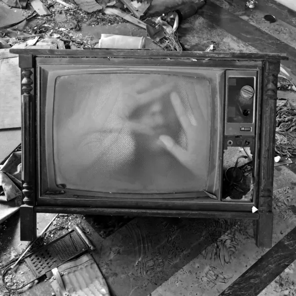 Призрачная фигура на винтажном телевизоре — стоковое фото