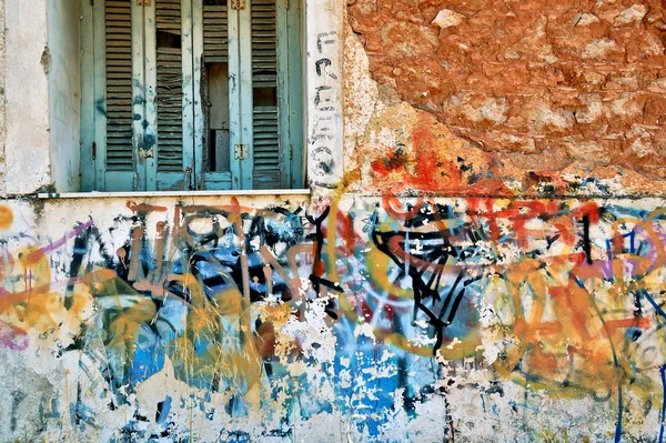 Övergivet husvägg med stökigt graffiti — Stockfoto