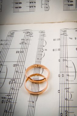 Wedding rings on the notes.music hearts clipart