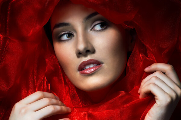 Beautiful girl in the red fabric