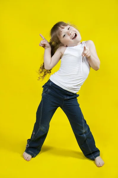 Menina alegre dança em um fundo amarelo — Fotografia de Stock