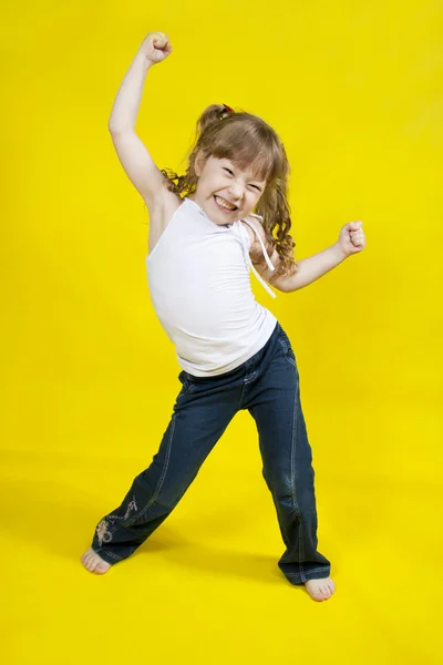 Fröhliches Mädchen tanzt auf gelbem Hintergrund — Stockfoto