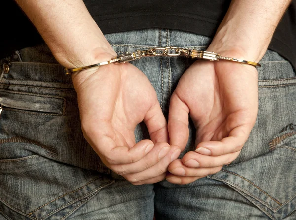 Злочинні руки заблоковані в наручниках — стокове фото