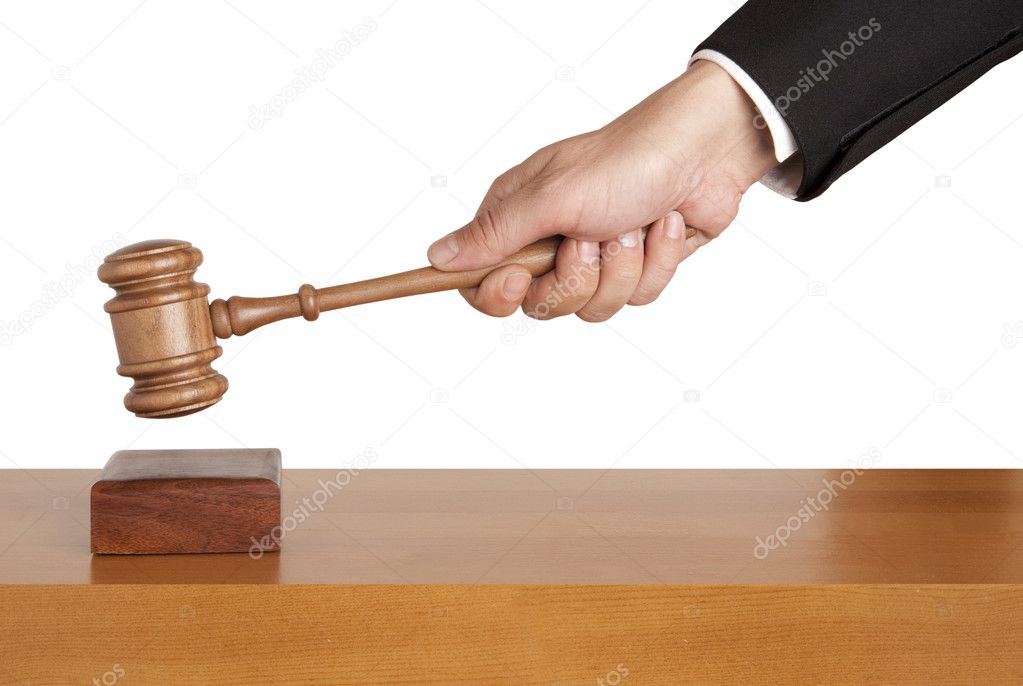 Human hand holding a wooden gavel isolated
