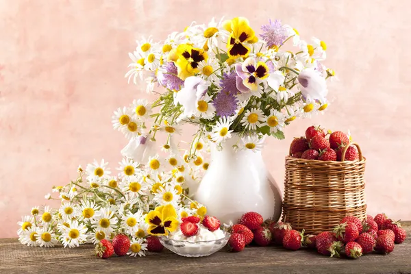 Strawberries and bouquet of flowers — Stock Photo, Image