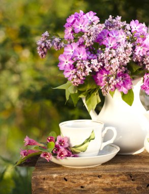 Porcelain cup with coffee and lilac clipart