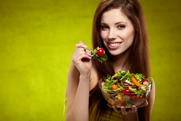 De mooie vrolijke jonge vrouw heeft ontbijt salade — Stockfoto