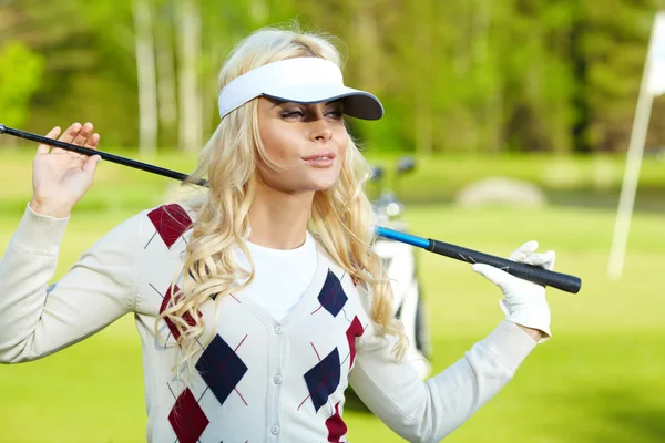 Porträtt av en elegant kvinna som spelar golf på en grön — Stockfoto