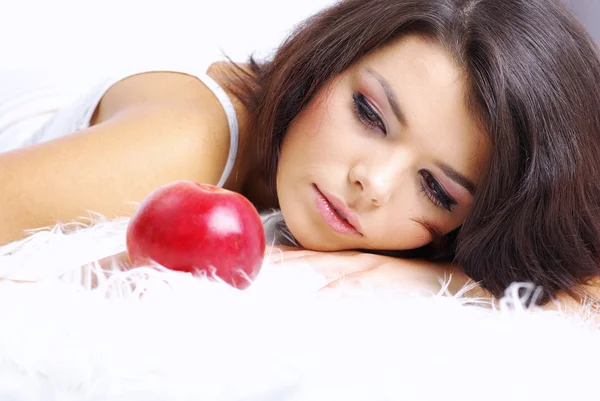 Πορτρέτο του γυναίκα κάθεται στο κρεβάτι και να τρώει φρέσκο κόκκινο μήλο — Φωτογραφία Αρχείου