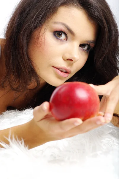 Retrato de la mujer sentada en la cama y comiendo manzana roja fresca — Foto de Stock
