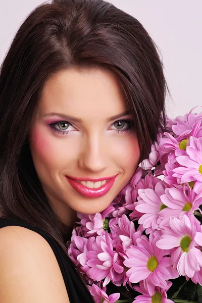Genç kadın yüzüyle çiçekler — Stok fotoğraf