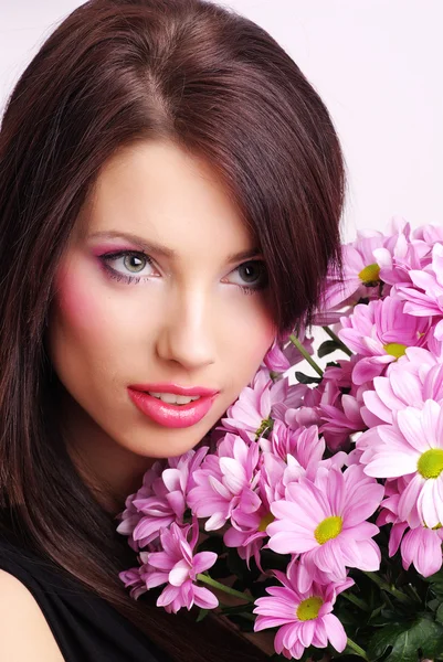 Genç kadın yüzüyle çiçekler — Stok fotoğraf