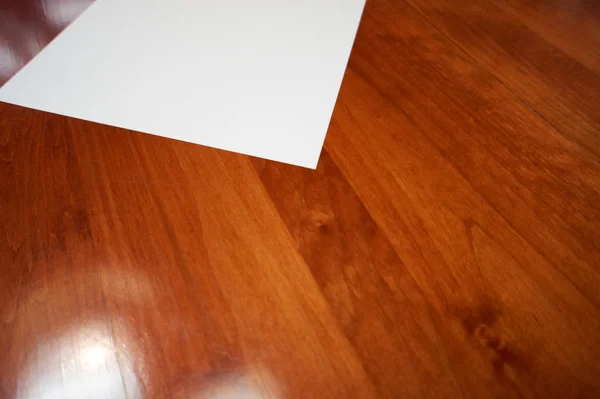Tomt vitt papper på gummi trä bakgrund — Stockfoto