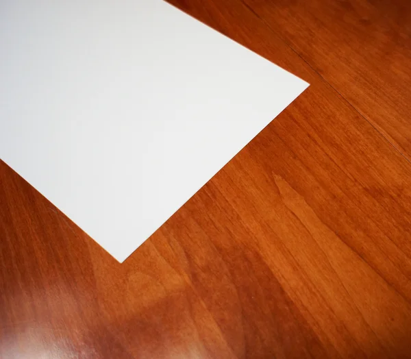 Tomt vitt papper på gummi trä bakgrund — Stockfoto