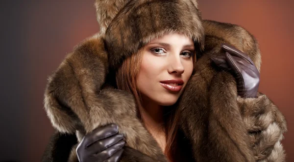Mujer atractiva en abrigo de piel marrón con capucha — Foto de Stock