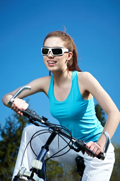 Joven mujer sexy en una bicicleta al aire libre sonriendo — Foto de Stock