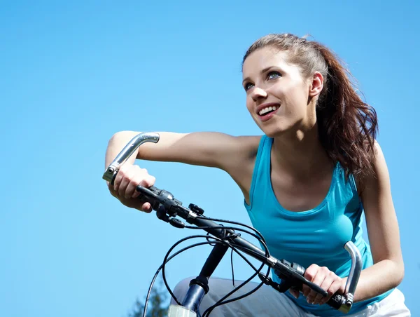 Женщина с велосипедом под голубым небом — стоковое фото