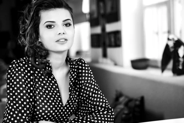 Sevimli seksi kadın siyah giysiler içinde muhteşem bir kafede oturuyor — Stok fotoğraf