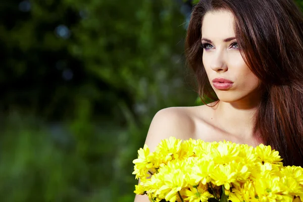 Sarı çiçekli gülümseyen sevimli genç kız closeup portresi — Stok fotoğraf