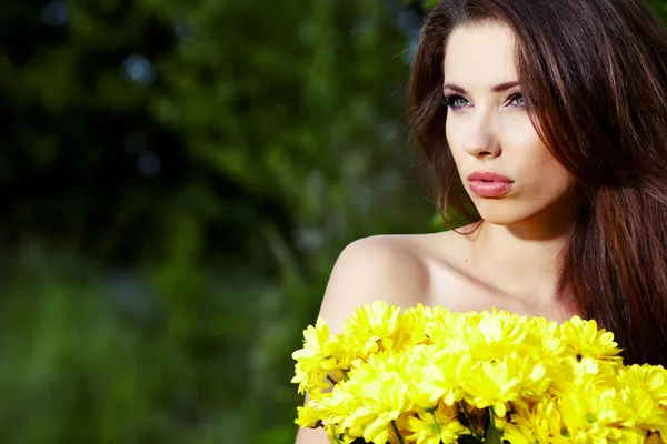 Gros plan portrait de mignonne jeune fille avec des fleurs jaunes souriant — Photo