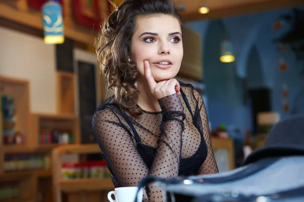 Çay ile kafede oturan genç kadın — Stok fotoğraf