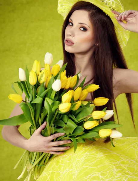 Jonge vrouw houd gele tulpen bloem op groen — Stockfoto