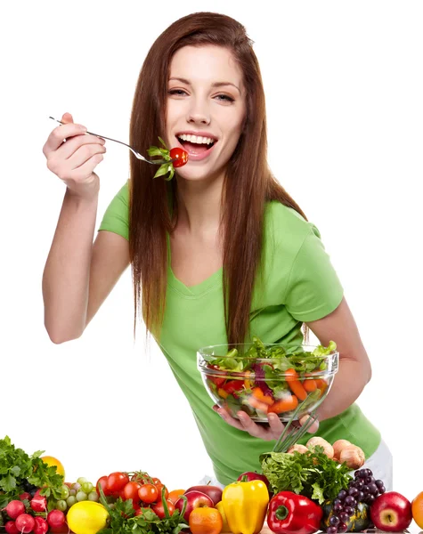 Portret van een mooie jonge vrouw eten plantaardige salade tegen — Stockfoto