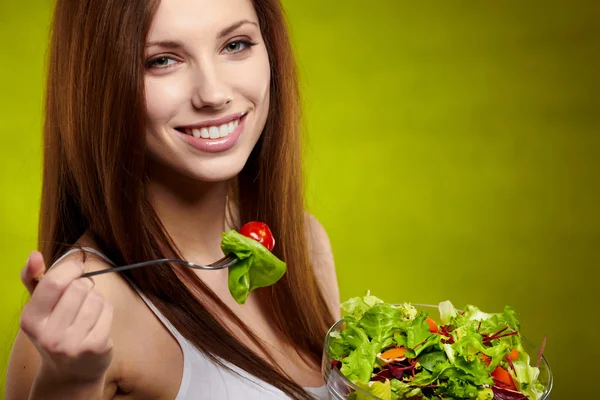 Healthy lifestyle - woman holding vegetable salad on green backg — Stock Photo, Image