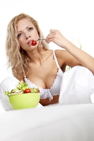 Blonďatá žena jíst salát — Stock fotografie