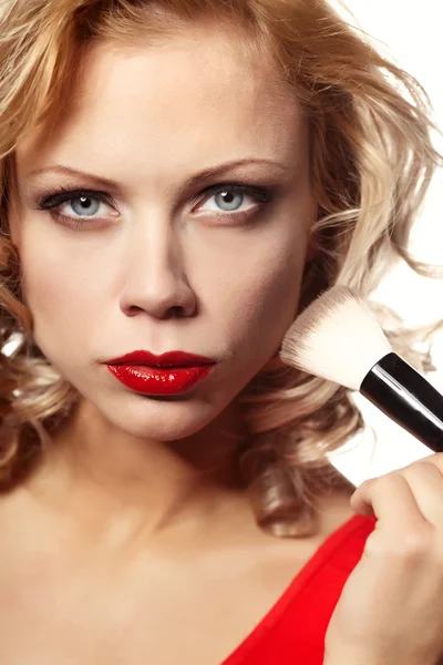 Mooie blonde vrouw toepassing van make-up op haar gezicht — Stockfoto