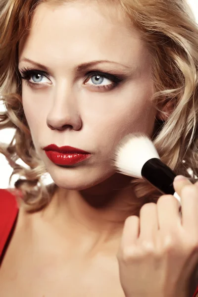 Hermosa mujer rubia aplicando maquillaje en su cara —  Fotos de Stock