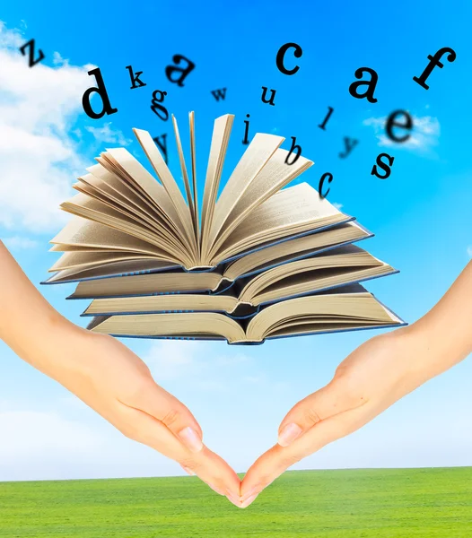 Magiczna książka i litery na ręce — Zdjęcie stockowe