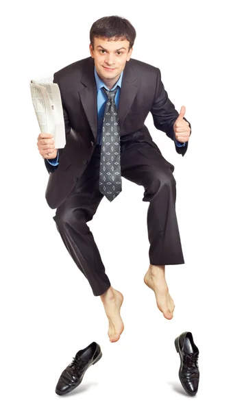 Businessman jumping with newspaper in hand — Stock Photo, Image