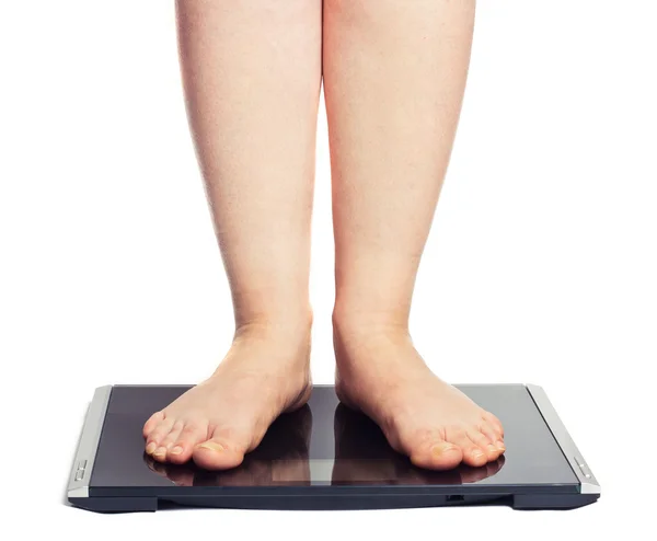 Stock image Bare female feet standing on bathroom scale