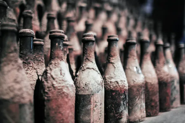 Garrafas de vinho velho coberto com poeira — Fotografia de Stock