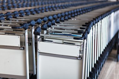 Lined up trolleys at airport clipart