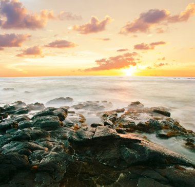 volkanik taşların plaj gün batımında. Hawaii
