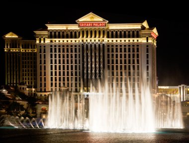 The Caesars Palace Hotel is shown behind some of the fountains o clipart