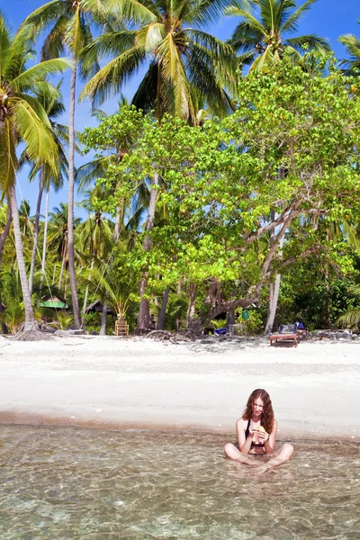 Vrouw aan het tropische strand — Stockfoto