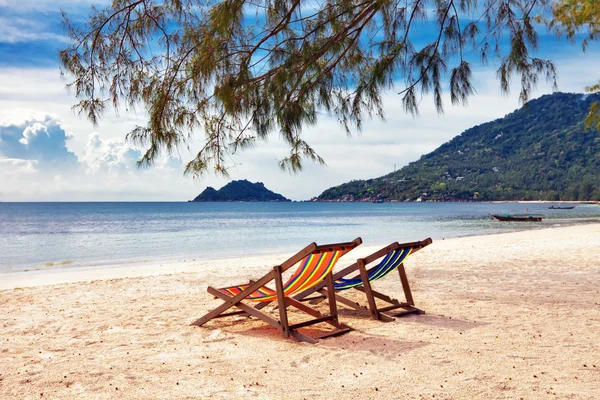 Two sun beach chairs on shore near sea — Stockfoto