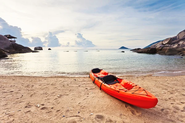 stock image Lonely red kayak at the tropical beach in gloomy weather.