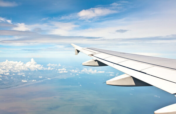 Голубое небо и вид на солнце над крылом
