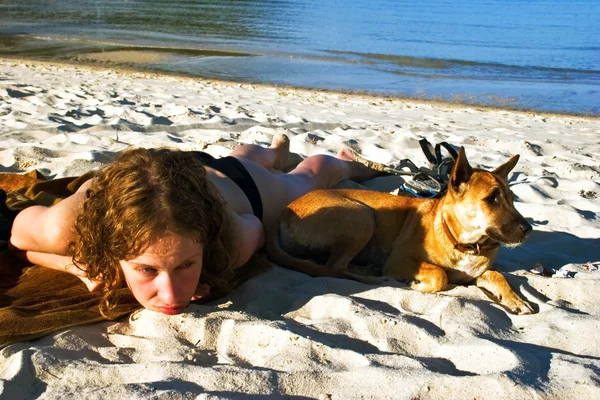 少女と犬のビーチで休んで — ストック写真