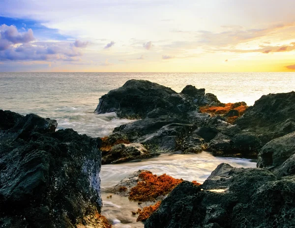Zonsondergang op vulkanische stenen strand. Hawaii — Stockfoto