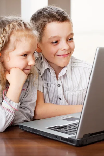 Gelukkige jonge geitjes laptop thuis spelen — Stockfoto