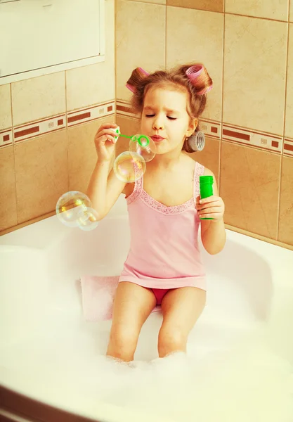 Kis lány blow buborékok a fürdőkádban — Stock Fotó