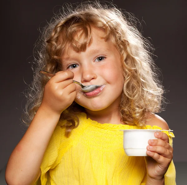 Yoğurt yiyen küçük kız. — Stok fotoğraf